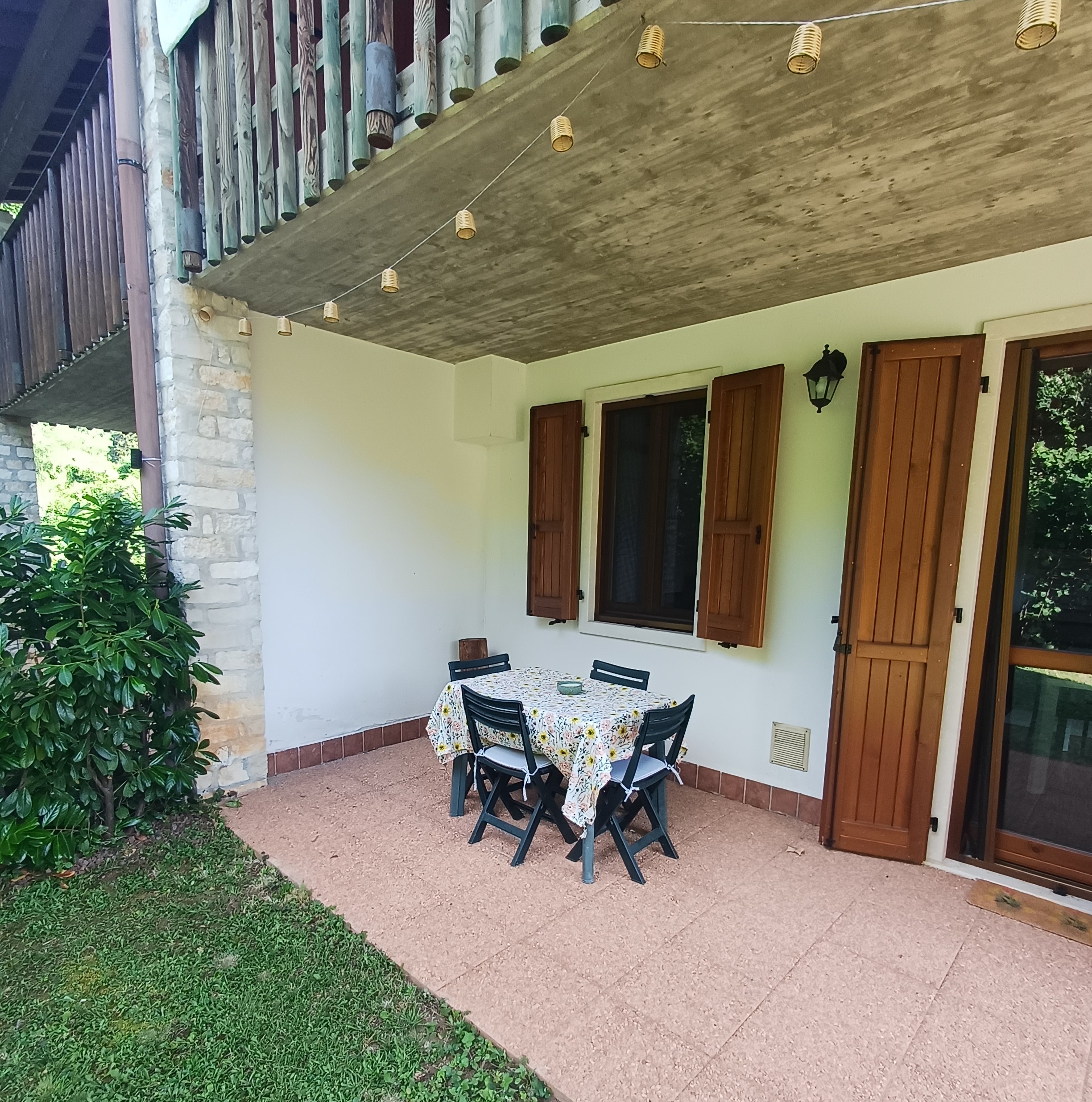 Terrazza coperta con tavolo da pranzo affacciata sul giardino